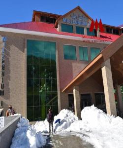 a university building with snow in front of it at Millennium Inn Naran in Mānsehra