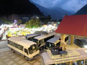 a group of buses parked in a parking lot at Millennium Inn Naran in Mānsehra