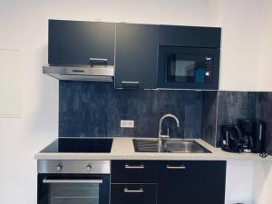 cocina con fregadero y microondas en Comfortable new Apartment in #Koblenz# direkt am Rhein, en Coblenza