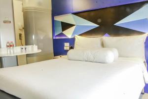A bed or beds in a room at MD 7 Hotel Cirebon