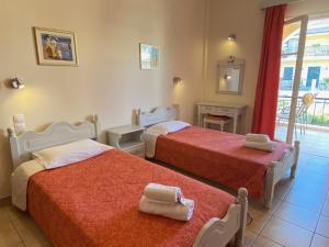 a bedroom with two beds with towels on them at Nikos Cassiopeia in Kassiopi