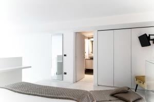 Como City Loft - byMyHomeinComo في كومو: غرفة معيشة مع دواليب بيضاء ومرآة
