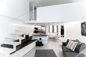uma sala de estar com um sofá e uma escada em Como City Loft - byMyHomeinComo em Como