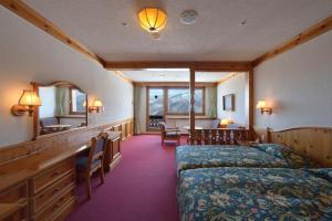 山之內的住宿－奧志賀鳳凰大酒店，一间卧室配有一张床、一张桌子和一面镜子
