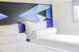 A bed or beds in a room at MD 7 Hotel Cirebon