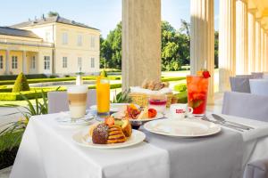 a table with plates of food and drinks on it at Károlyi Kastély Hotel & Restaurant in Fehérvárcsurgó