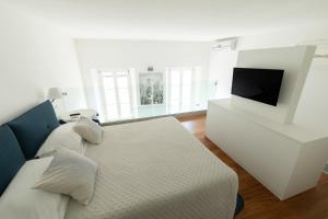 a white living room with a couch and a tv at Palazzo Torriglioni in Ancona