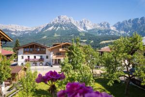 a view of a mountain from a town with purple flowers at Haus Salina in Ellmau