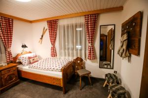 een slaapkamer met een bed, een stoel en een raam bij Haus Salina in Ellmau