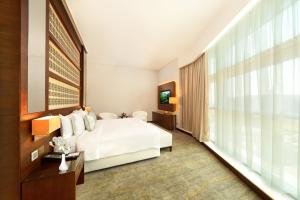 Een bed of bedden in een kamer bij dusitD2 Salwa Doha