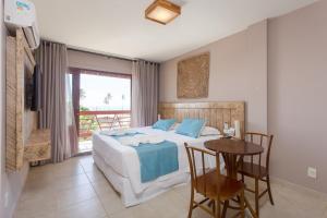 Un dormitorio con una cama y una mesa con sillas. en Pousada Iandê, en Porto de Galinhas 98 fotos más