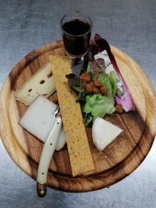 un plateau de fromage, une salade et un verre de vin dans l'établissement Hotel Axat, à Axat