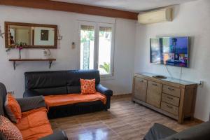 een woonkamer met een bank en een dressoir bij Paradise Ebro 2 in Deltebre