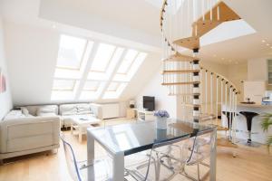 شقة فيينا وان شميدغاسه في فيينا: غرفة معيشة مع طاولة زجاجية ودرج حلزوني