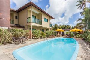 a swimming pool in front of a house at Pousada Iandê in Porto De Galinhas