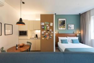 a bedroom with a bed and a table and a kitchen at Bloom House by Sweet Porto in Porto