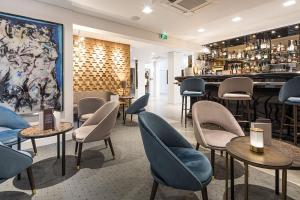 un restaurant avec des chaises et des tables ainsi qu'un bar dans l'établissement Hotel Relais Saint Jean Troyes, à Troyes