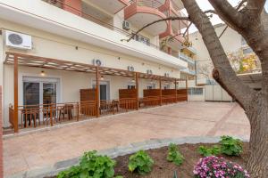 a large building with a patio and a tree at Amaryllis Maison Hili in Alexandroupoli