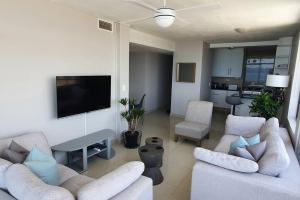 a living room with two couches and a flat screen tv at LICORNA BEACH 51 UMHLANGA BEACHFRONT in Durban