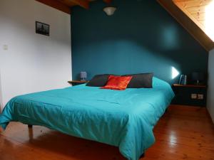 ein blaues Schlafzimmer mit einem Bett mit einem roten Kissen in der Unterkunft Appartement dans chalet avec jardin, vue montagne in Aucun