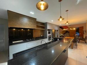 a kitchen with a large counter top in a room at Casa Escarpas do Lago, 4 suítes e ar-condicionado in Capitólio