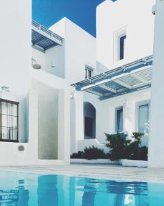 a white house with a pool in front of it at Palmariva Villas in Fira