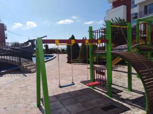 a playground with a slide and swings at On the beach in Elenite