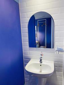 y baño con lavabo blanco y espejo azul. en Dafam Express Jaksa Jakarta, en Yakarta