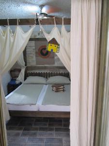 a bedroom with a bed with curtains and a toy house hanging at Apartments Voltera parking space near the house in Betina