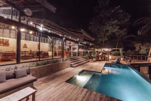 a swimming pool on a wooden deck at night at Villa Kiri, Secluded Jungle Paradise in Selong Belanak
