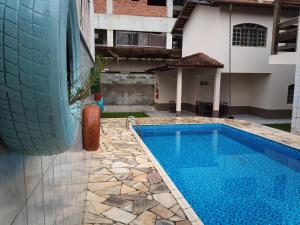 uma piscina ao lado de uma casa com um pneu na parede em Lionfish Hostel em Caraguatatuba