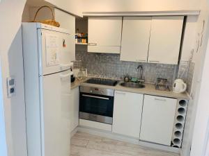 a kitchen with white cabinets and a white refrigerator at Les Remparts Antibes Location in Antibes