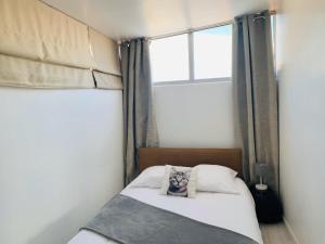 a small bedroom with a bed and a window at Les Remparts Antibes Location in Antibes