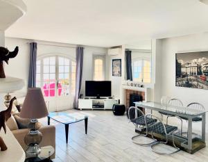 a living room with a couch and a tv at Les Remparts Antibes Location in Antibes