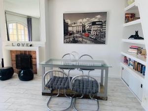 a living room with a glass table and two chairs at Les Remparts Antibes Location in Antibes