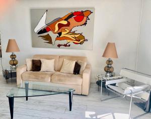 a living room with a couch and two tables at Les Remparts Antibes Location in Antibes