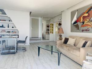 a living room with a couch and a glass table at Les Remparts Antibes Location in Antibes