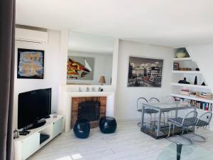 a living room with a tv and a fireplace at Les Remparts Antibes Location in Antibes