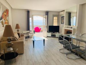 a living room with a couch and a tv at Les Remparts Antibes Location in Antibes