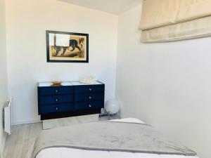 a bedroom with a blue dresser and a blue cabinet at Les Remparts Antibes Location in Antibes