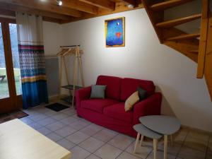 ein Wohnzimmer mit einem roten Sofa und einem Tisch in der Unterkunft Appartement dans chalet avec jardin, vue montagne in Aucun