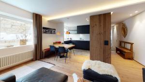 a living room and kitchen with a table and chairs at Paravicini 5 in St. Moritz