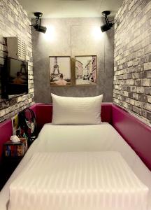 Cama en habitación con pared de ladrillo en The First Nanwan Hostel, en Nanwan