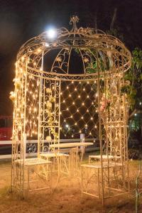 a metal gazebo with lights in a park at night at The Creek Villa in Loei