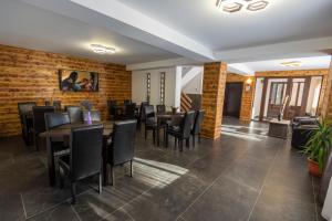 a dining room with tables and chairs and a brick wall at Casa Raisa in Buşteni