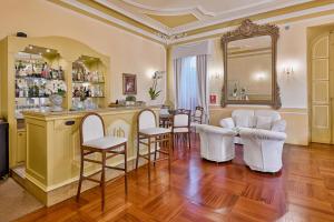 a room with a bar with chairs and a mirror at Hotel Paradiso in Sanremo