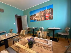 un restaurant avec des tables et des chaises et une peinture murale. dans l'établissement Hotel de Normandie, à Gournay-en-Bray