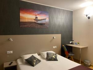 - une chambre avec un lit et un bateau sur le mur dans l'établissement Hotel de Normandie, à Gournay-en-Bray
