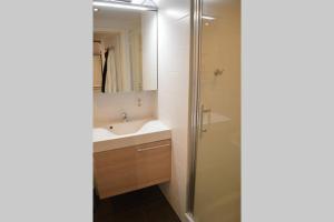 een badkamer met wastafel en douche bij Nieuwbouwappartement met zeezicht in Koksijde bad in Koksijde +35 foto's
