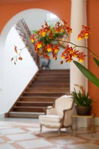 un corridoio con una scala con sedie e fiori di Casa Marambaia Hotel a Petrópolis